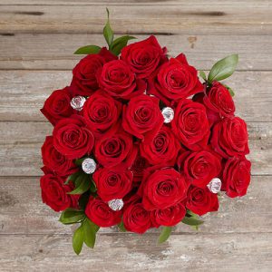 Rote Rosen von oben auf Holztisch